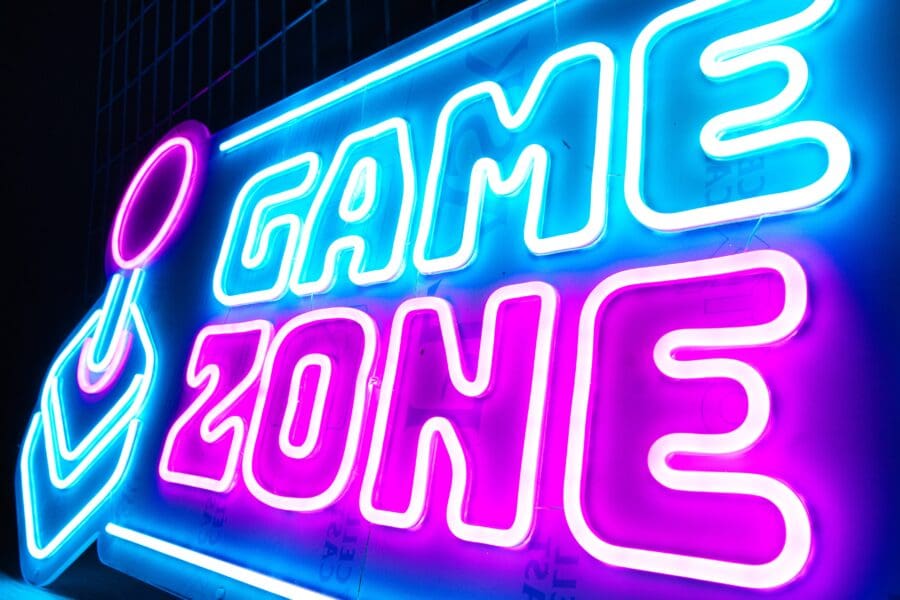 Una vibrante zona de juego de neón que muestra las palabras "zona de juego" en colores azul y rosa brillantes.