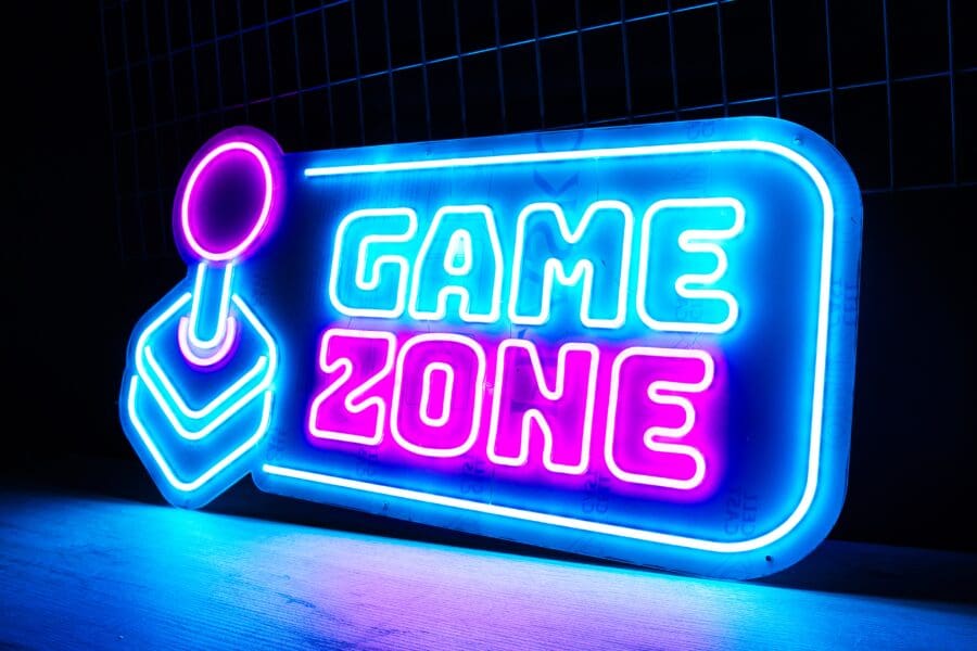 Neón Game Zone iluminado en colores azul y rosa mostrando las palabras "gamezone".