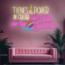 Un sofá rosa con un letrero de neón Neón Tienes el poder de crear la vida de tus sueños.