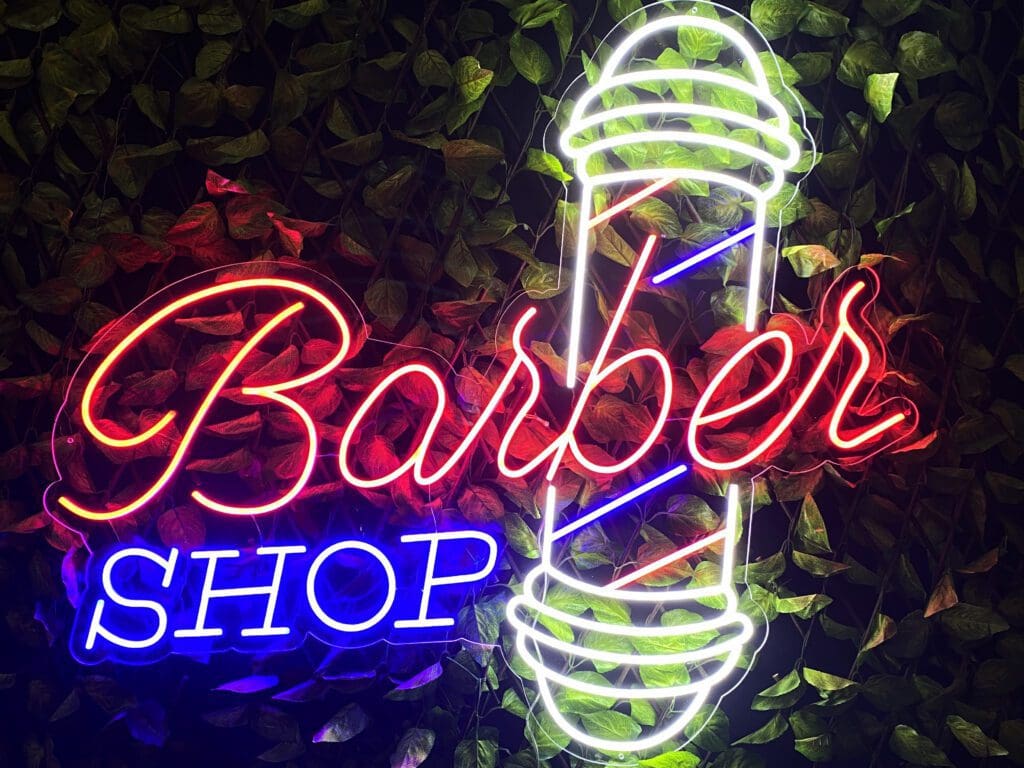 Un letrero de neón Barber Shop Peluquería.