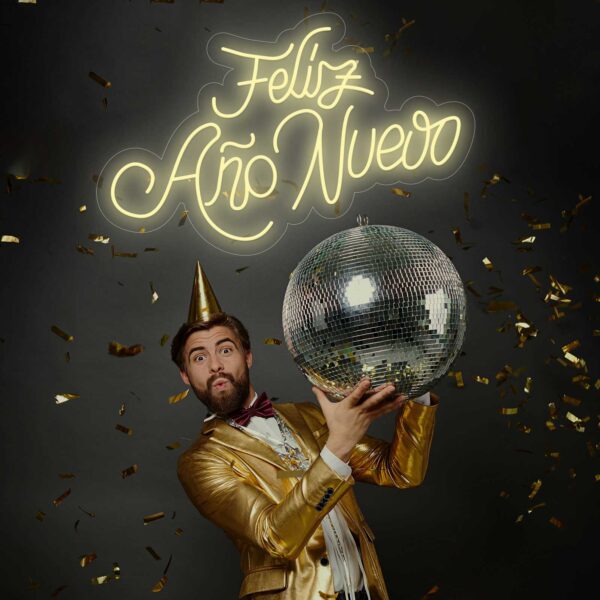 Un hombre feliz con un traje dorado sosteniendo una bola de discoteca Neón Feliz Año Nuevo.