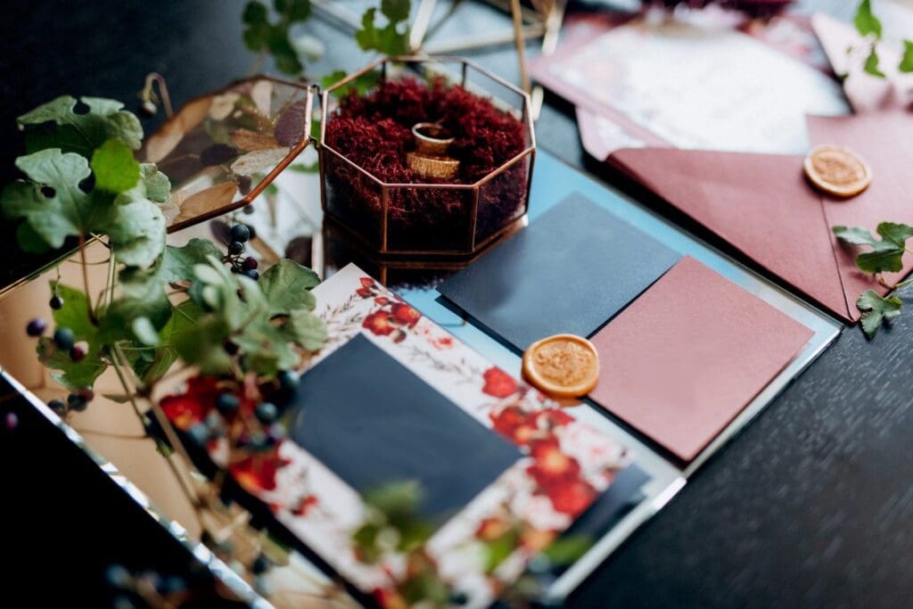 Un juego de papelería de boda con flores y hojas sobre una mesa.