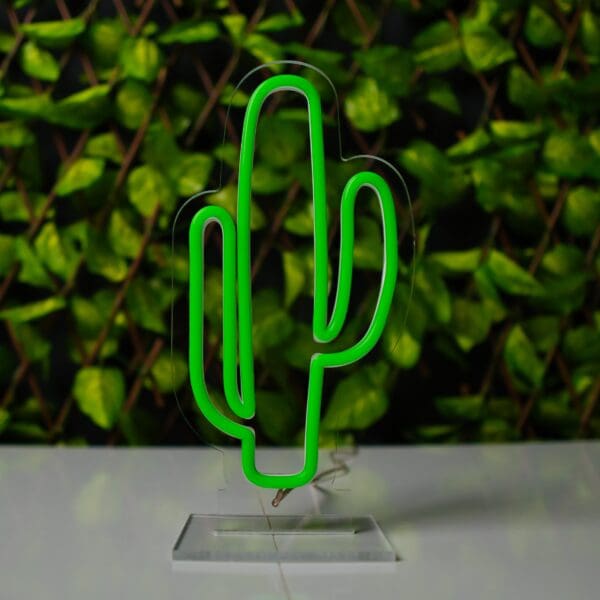 Un letrero verde de Lámpara de Néon Cactus sobre una mesa.