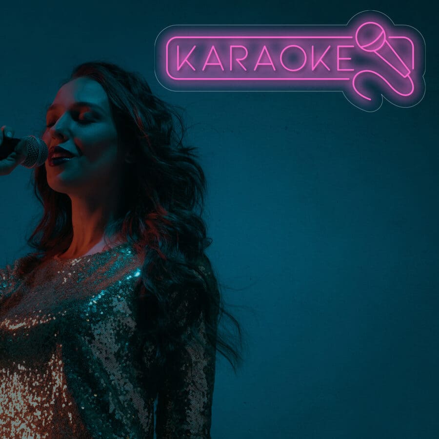 Una persona con un atuendo brillante canta frente a un micrófono junto a un letrero de Neón Karaoke sobre un fondo oscuro, listo para que los fanáticos se tomen una selfie.