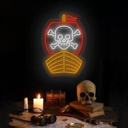 Letrero de neón de barco pirata con una calavera y huesos cruzados sobre una vela encendida, una lupa, libros, una calavera, un pequeño cofre y binoculares sobre una mesa oscura.