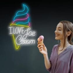 Una mujer sonriendo y sosteniendo un cono de helado está junto a un letrero de neón que dice "AMO el helado", con una imagen de neón de un cono de helado.