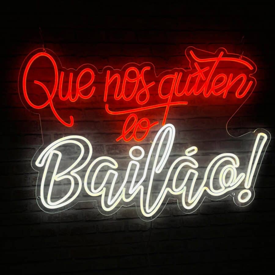 Letrero de neón con la frase "¡Que nos quiten lo bailao!" en letras rojas y blancas sobre fondo oscuro.