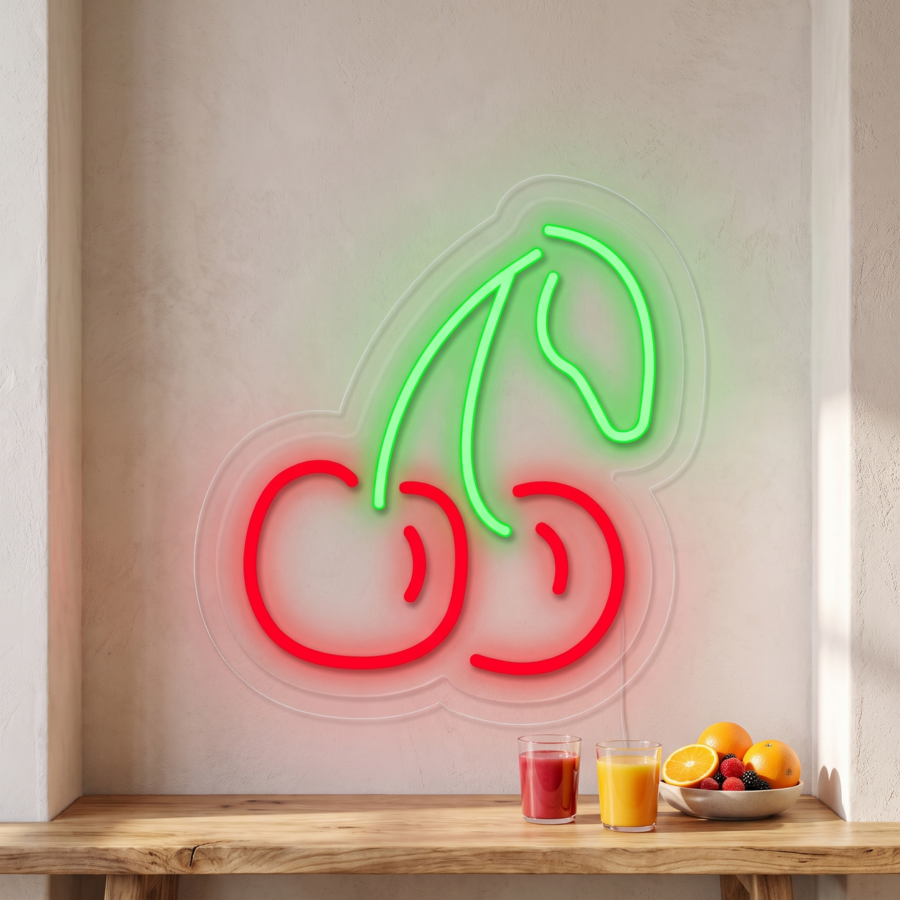 Un letrero de neón con dos cerezas cuelga de una pared blanca, sobre una mesa de madera en la que hay dos vasos de zumo y un cuenco con fruta variada.