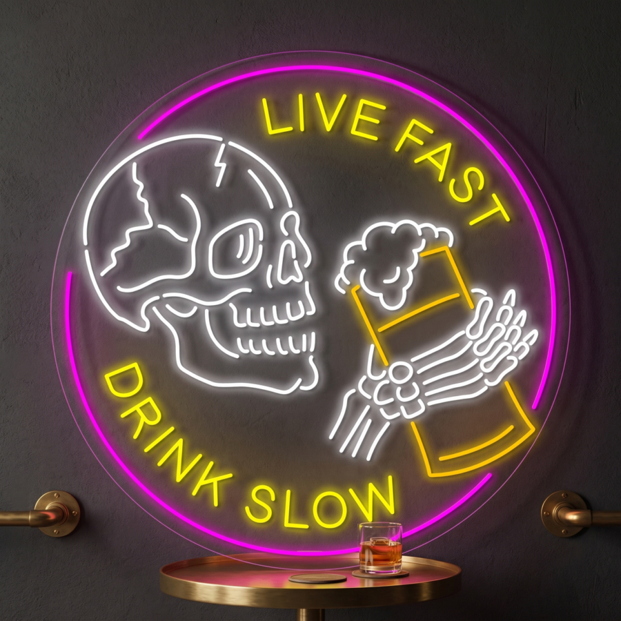 Letrero de neón con la imagen de una calavera que sostiene una jarra de cerveza y la frase «LIVE FAST DRINK SLOW» en letras amarillas, sobre una mesa redonda en la que hay un vaso de whisky.