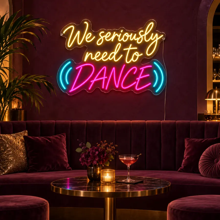 Montaje del letrero LED neón «We seriously need to dance» en un salón de baile elegante con pared burdeos, bancada tapizada y luz de tarde