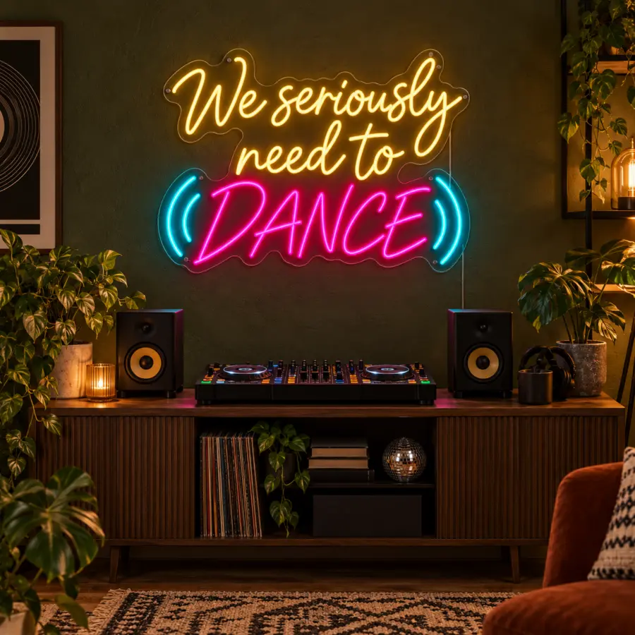 Montaje del letrero LED neón «We seriously need to dance» en un rincón de DJ doméstico con consola compacta, altavoces y luz práctica cálida