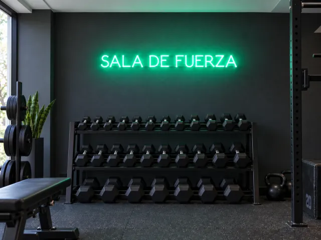 Sala de fuerza en letras de neón verde en un gimnasio